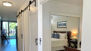 Habitación de hotel con cama, escritorio y puerta corredera que da a un balcón.