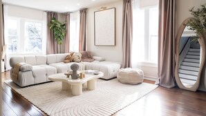 Una sala de estar moderna con un sofá modular, una mesa de centro y una planta grande en maceta.