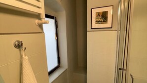 A small bathroom with a toilet, a shower, and a window. - The Coccagna Hideaway Secret Whispered in the Alleys (Genova)