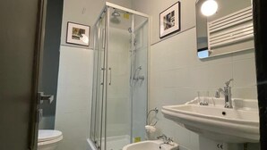 A bathroom with a glass-enclosed shower, a bidet, a sink, and a toilet. - The Coccagna Hideaway Secret Whispered in the Alleys (Genova)