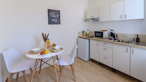 A modern kitchen with white cabinets, a dining table with two chairs, and a blackboard with the text "Take it easy". - Delmas - 5min Centre Ville - Wifi (Saint-Quentin)