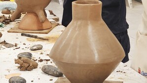Een keramiekatelier met kleipotten en gereedschap.