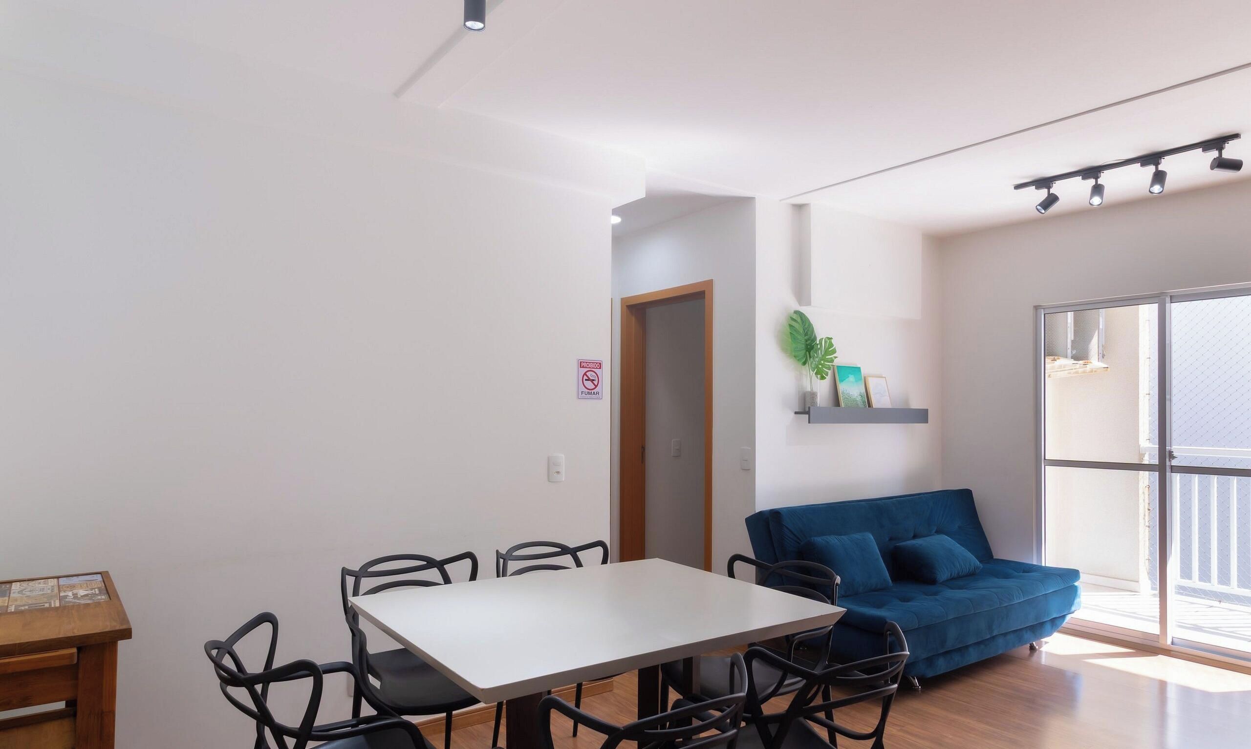 Ein moderner Wohnraum mit Essbereich, einer Couch und einem Fenster mit Tageslicht.
