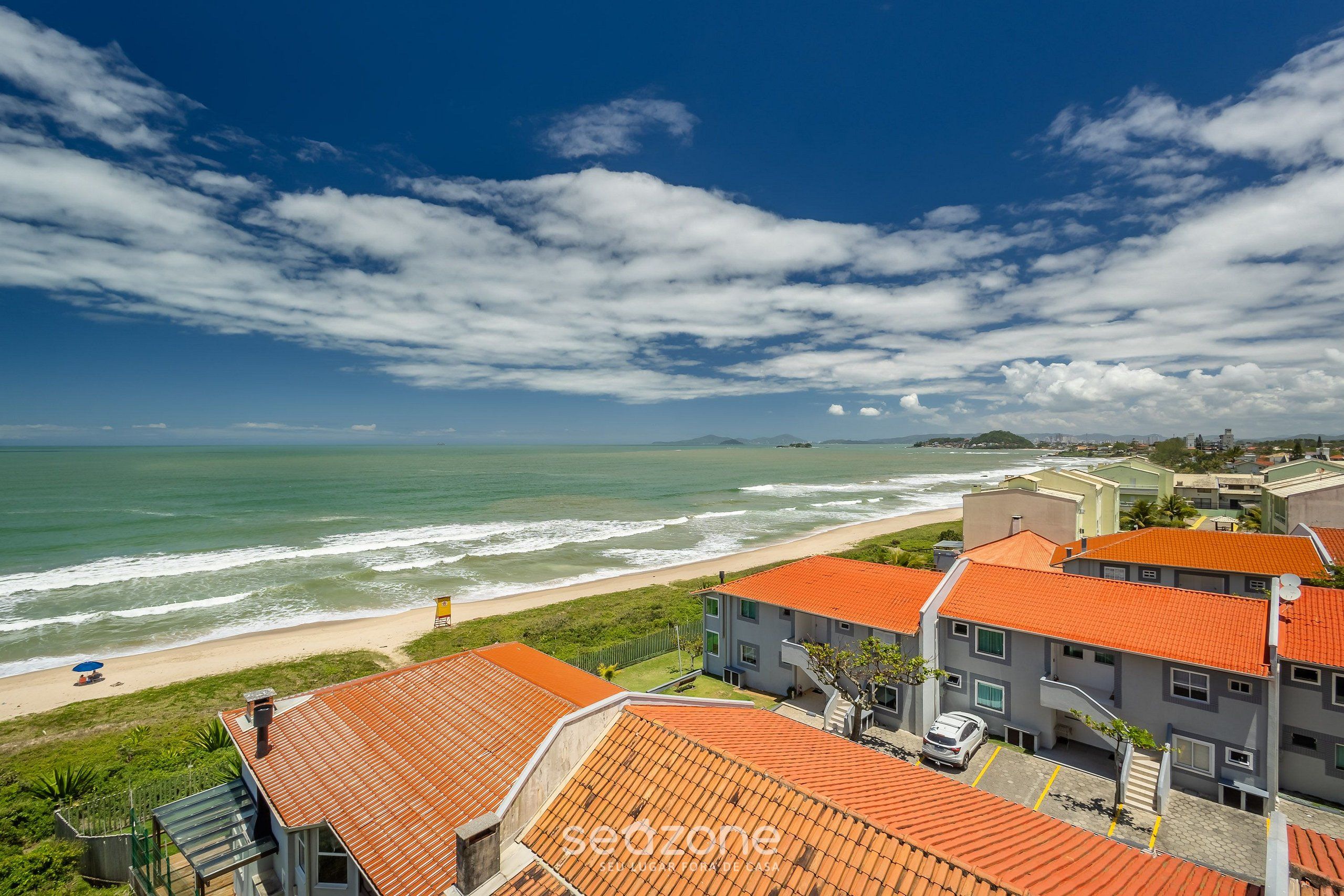 Zona residencial costera con edificios, una playa y el océano.