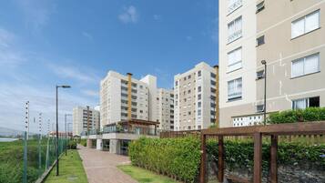 Un conjunto residencial con varios edificios de apartamentos, un camino pavimentado y una pequeña zona cubierta con asientos.