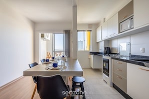 Una cocina moderna con comedor, ventanas amplias y vista a la ciudad.