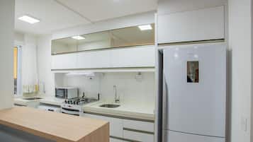Una cocina moderna con microondas, estufa, lavaplatos y refrigerador integrados.