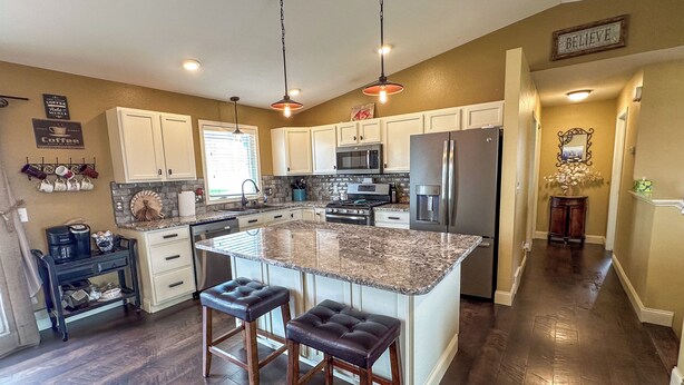 A modern kitchen with a large island, stainless steel appliances, and a bar stool seating area. - Spacious/Clean 4 Bedroom 2 Bathroom Home away from Home. (Mandan)