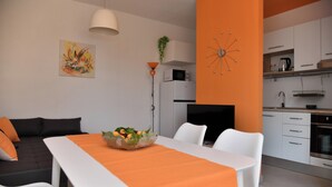 A modern living room with a dining area, a kitchen, and a TV. - A2 Apartment With Terrace, 1 min Walk to the Beach (Supetar)