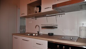 A modern kitchen with a stainless steel sink, a built-in oven, and a range hood. - A2 Apartment With Terrace, 1 min Walk to the Beach (Supetar)