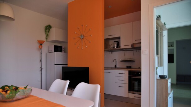 A modern kitchen with white cabinets, a microwave, and a clock on the wall. - A2 Apartment With Terrace, 1 min Walk to the Beach (Supetar)