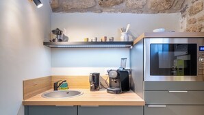Eine Küche mit Spüle, Kaffeemaschine und Mikrowelle.
