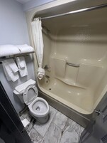 Bañera con ducha, toallas, jabón, shampoo