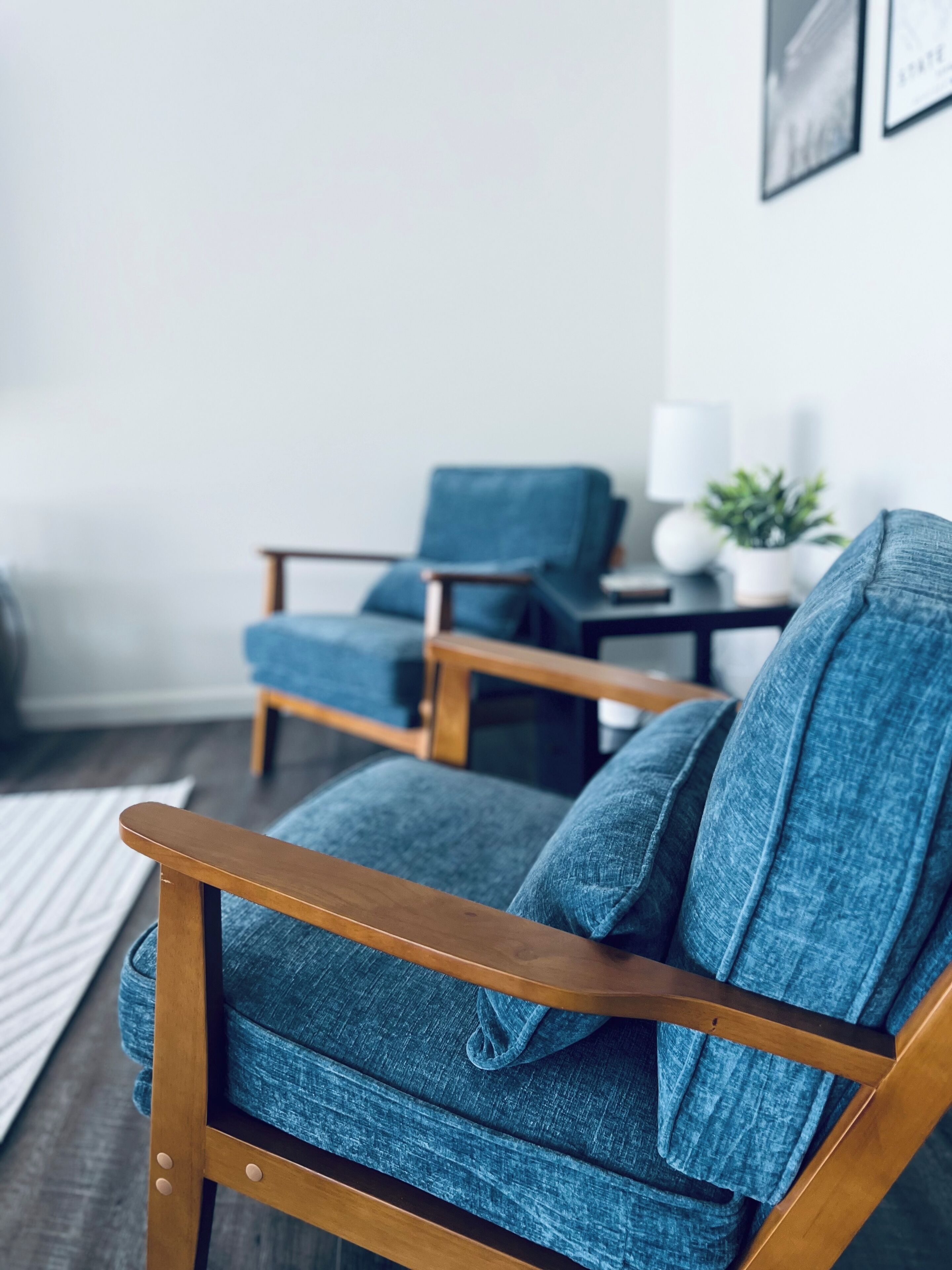 A modern living room with a blue armchair and a matching sofa.