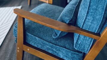 A modern living room with a blue armchair and a matching sofa.