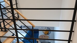 Puinen portaikko, jossa on mustat kaiteet, johtaa alemmalle tasolle.