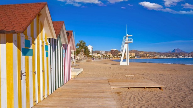 A beach with colorful beach huts and a lifeguard tower. - Bright flat 50m from the beach with swimming pool and car park (El Campello)