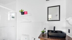 A modern bathroom with a shower, toilet, sink, and a mirror. - Exuma Studio w/ King Bed • Ideal for Couples or Solo Travel • Near George Town (George Town)