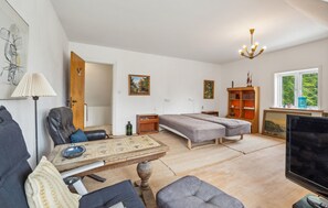 A modern living room with a sofa, two beds, a coffee table, a TV, and a bookshelf. - 3 bedroom lovely home in Nykøbing M (Nykøbing M)