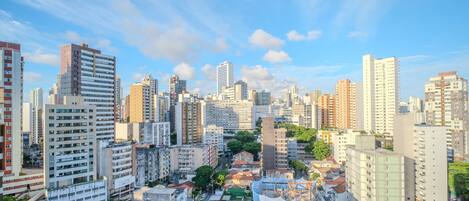 Un paisaje urbano con rascacielos, una combinación de edificios residenciales y comerciales, y un cielo despejado.