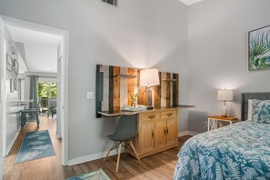 A bedroom with a bed, a desk with a chair, a wooden dresser, and a nightstand with a lamp. - 2402 Lighthouse Tennis at The Sea Pines Resort (Hilton Head Island)