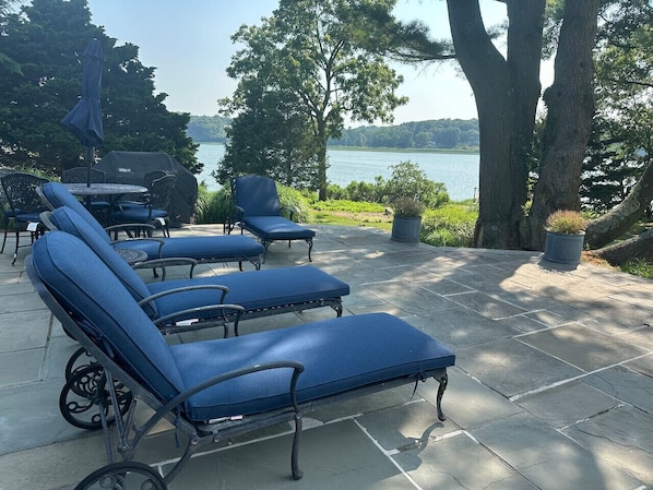 Outdoor lounge chairs with a view of a lake.