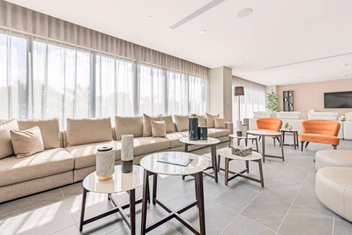 A modern living room with a sofa, coffee tables, and a TV.