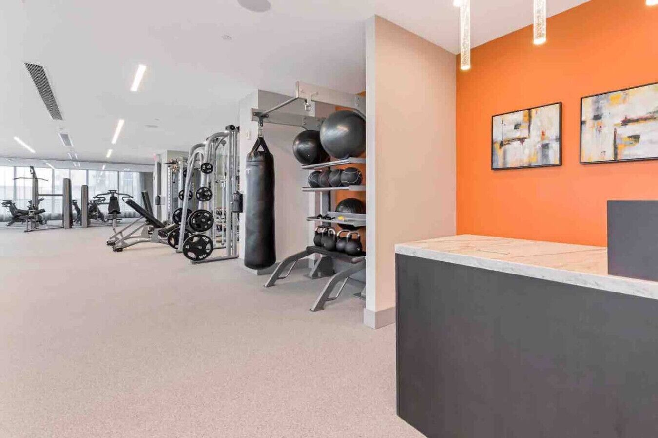 Et fitnessrum med vægttræningsudstyr, kettlebells og træningsbolde.