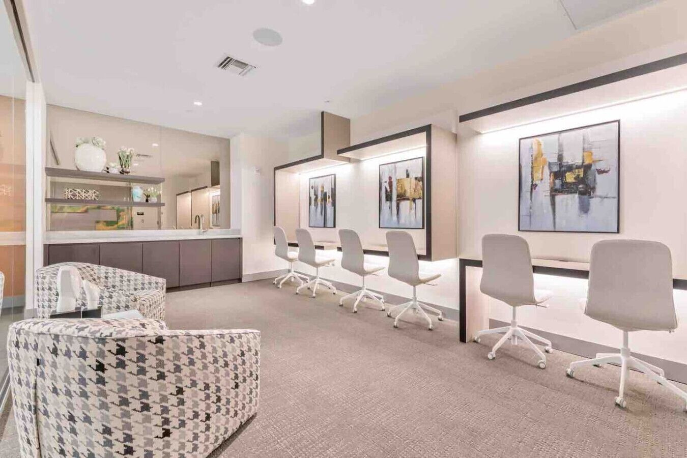 A modern meeting room with a long table, several chairs, and artwork on the walls.