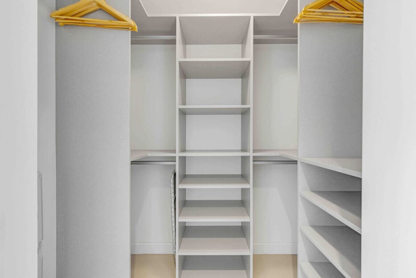A walk-in closet with multiple shelves and hanging space.
