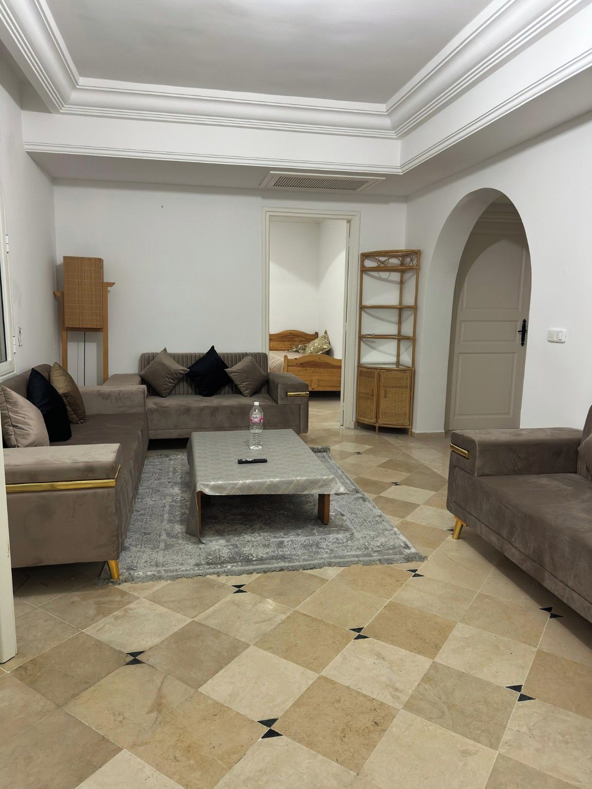 A living room with a sofa, a coffee table, and a patterned rug.