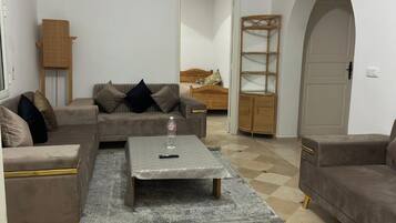 A living room with a sofa, a coffee table, and a patterned rug.