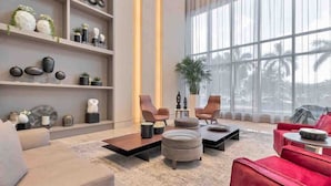 Un salon moderne avec une grande fenêtre, un canapé rouge, un canapé beige et une table basse.
