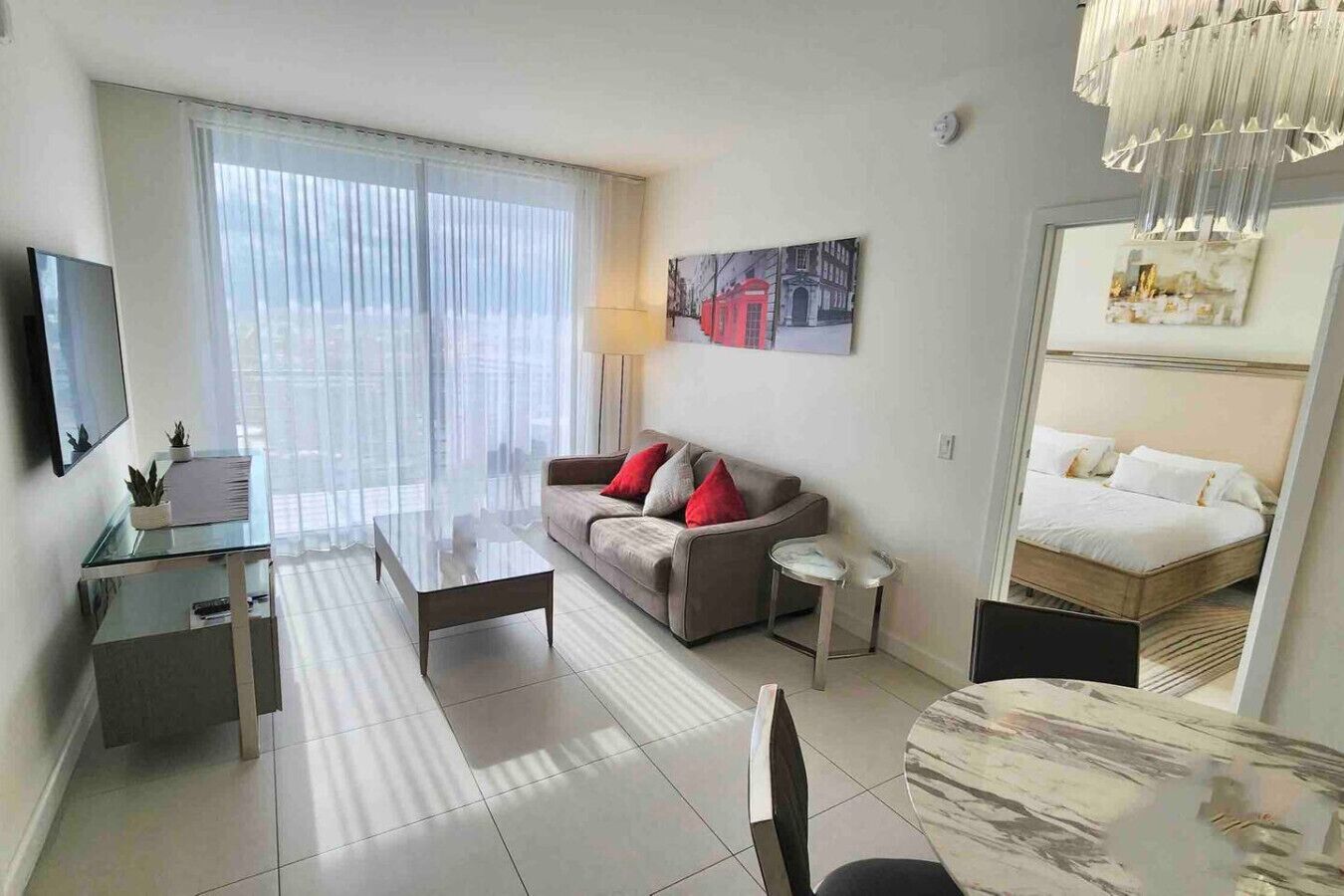 Une chambre d’hôtel moderne équipée d’un canapé, d’une petite table, d’une télévision et d’un lit.