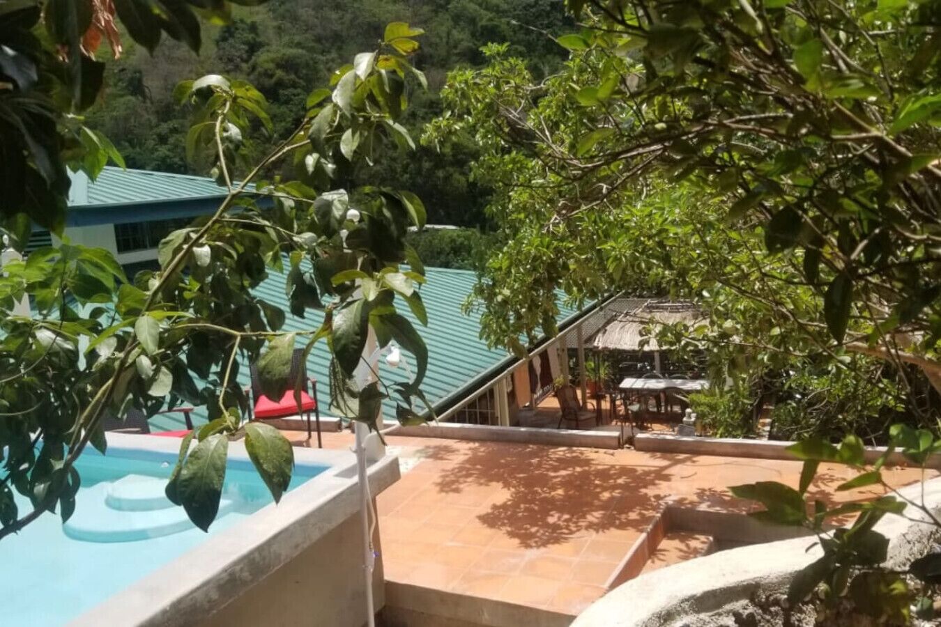 A pool area with a view of a building and trees in the background.