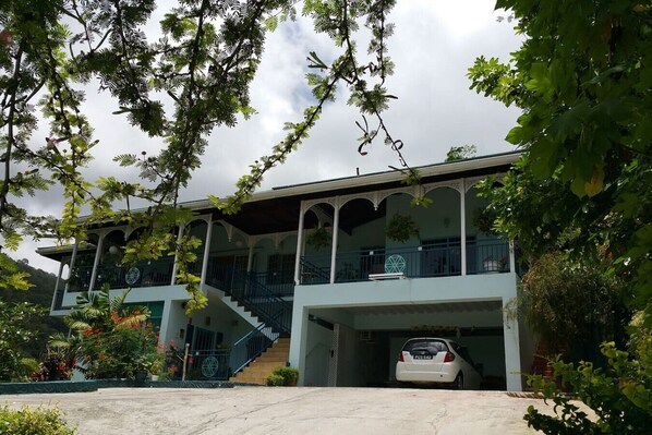 A two-story building with a covered staircase and a car parked in the garage.