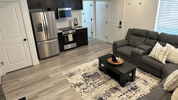 Un salon moderne avec un canapé gris, une table basse et un tapis à motifs.