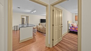 A modern apartment with a kitchen, dining area, and a bedroom.