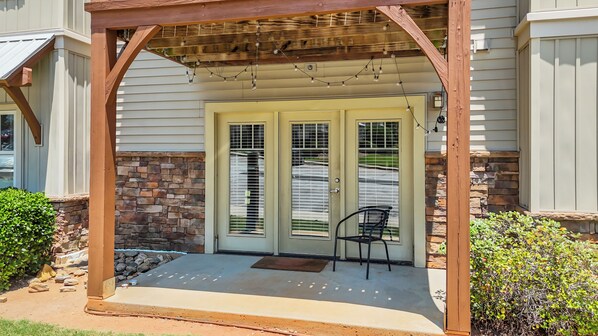 A covered porch with a stone wall, a bench, and a door with a window. - NEWLY FURNISHED 4BR/4BA condo 8 mins from Memorial Stadium 15 mins from Clemson! (Seneca)