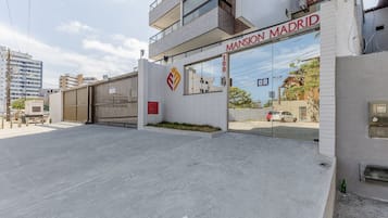 A building with a sign reading "Mansion Madrid" and a number "100" on the facade.