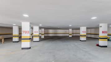A parking garage with white pillars marked with numbers and yellow stripes.