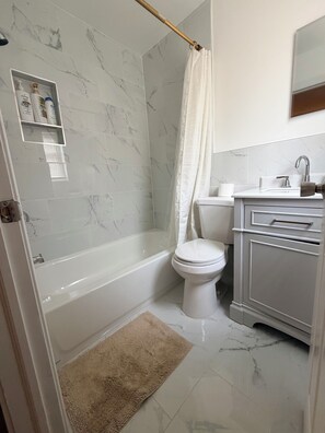 A bathroom with a bathtub, toilet, and sink.