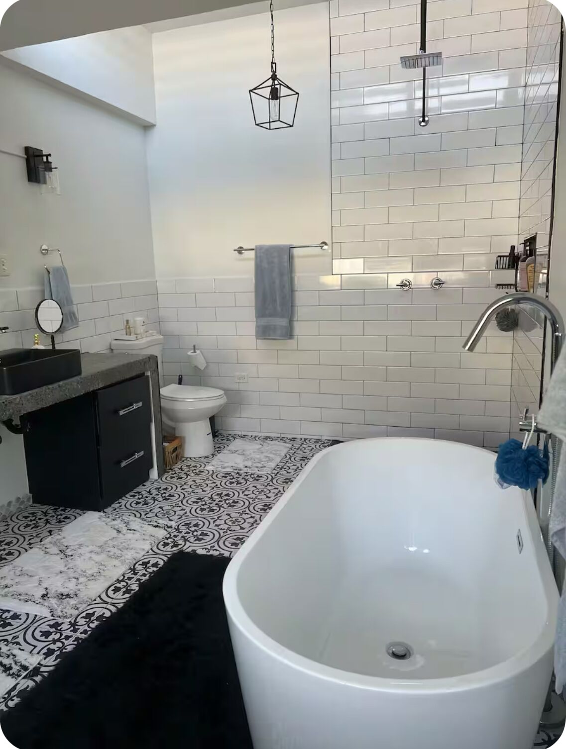 Une salle de bain moderne avec une baignoire sur pieds, des toilettes et un meuble-lavabo avec un miroir.