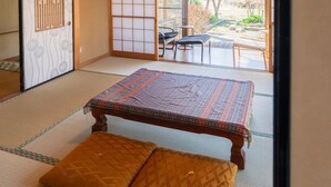Una habitación con esteras de tatami, una mesa baja y cojines.