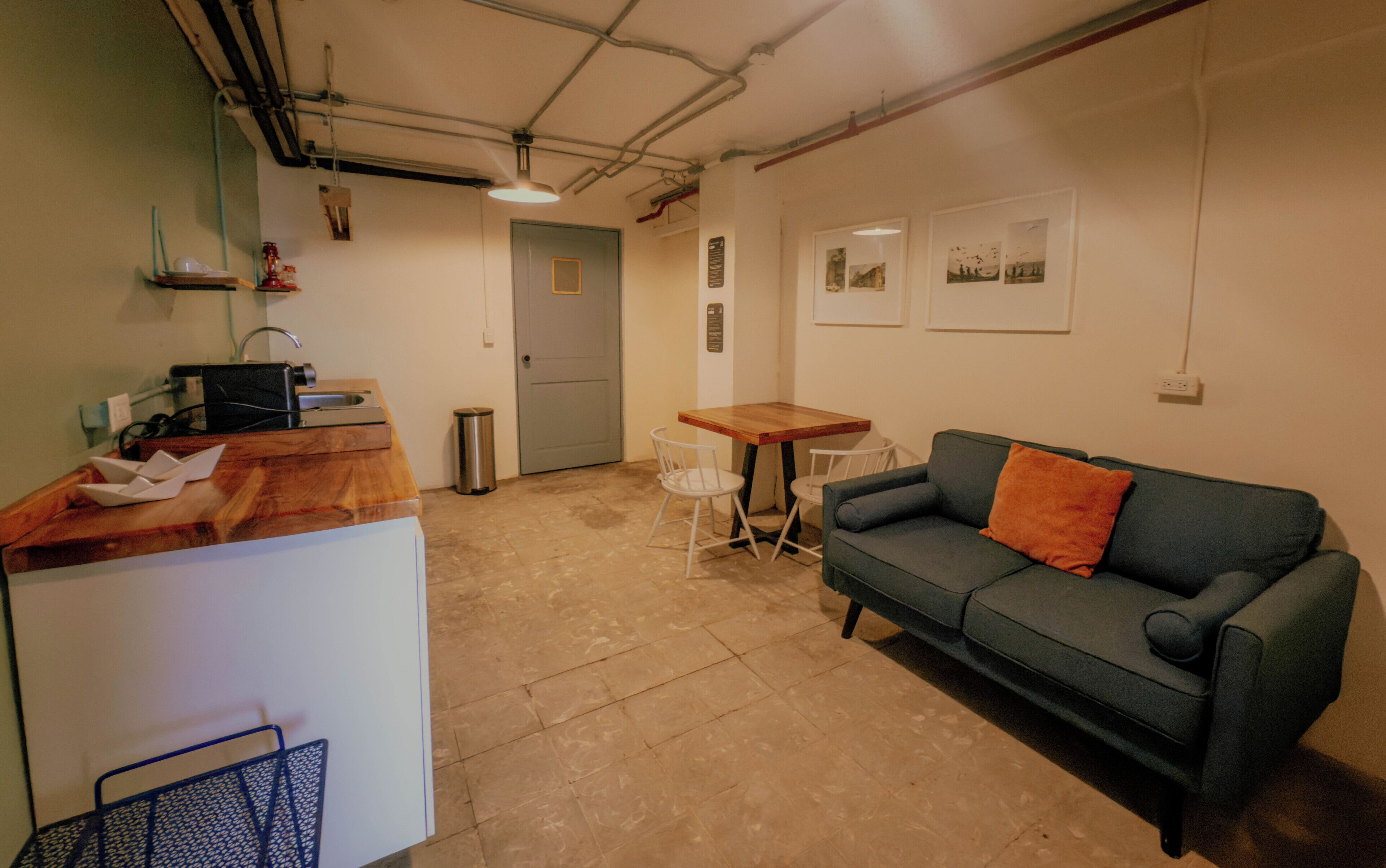 A compact living space with a kitchenette, a dining table, and a sofa.