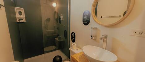 A bathroom with a toilet, sink, and shower.