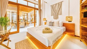 Ein modernes Schlafzimmer mit einem großen Bett, einem Holzkopfteil und Blick auf den Essbereich.