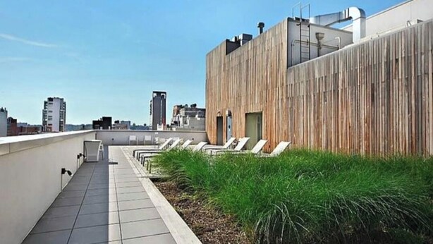 A rooftop terrace with a wooden wall, a tiled floor, and a row of sun loungers. - Spacious, luxury, central 3-bed, toilet, laundry apartment with dishwasher (New York)