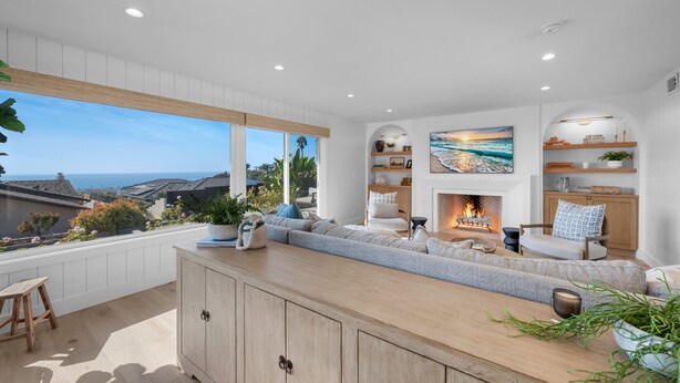 A modern living room with a large window, a fireplace, and a view of the ocean. - Oceanview Bliss - San Clemente (San Clemente)