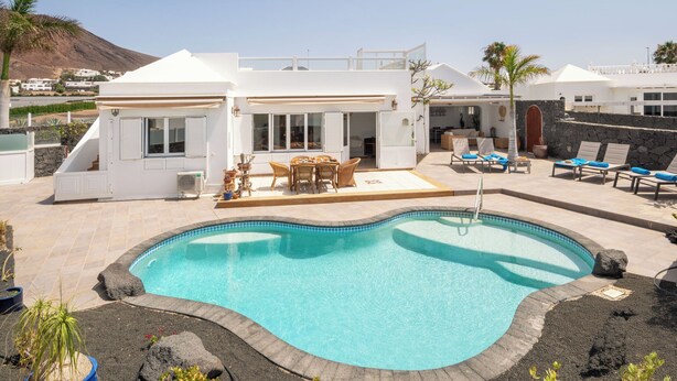 A modern villa with a swimming pool, outdoor seating, and a view of the surrounding landscape. - SAMARALDE by Buenavilla | Sea Views, Private Heated Pool in Playa Blanca (Playa Blanca)